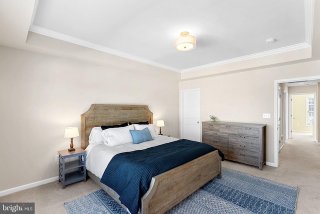 carpeted bedroom featuring crown molding and a tray ceiling