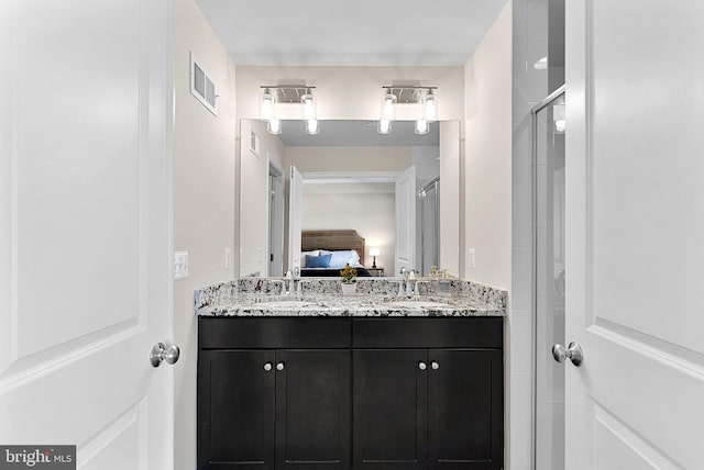 bathroom with a shower with shower door and vanity