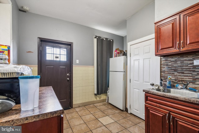 kitchen featuring white fridge, light tile patterned floors, and sink