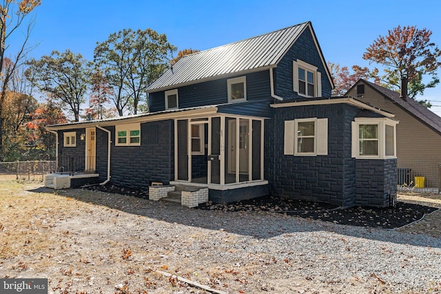 back of property with a sunroom