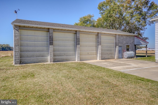 garage featuring a carport and a lawn