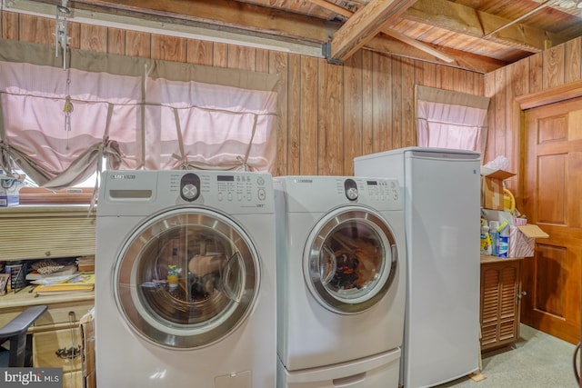 washroom with carpet flooring, wooden ceiling, wooden walls, and washing machine and clothes dryer