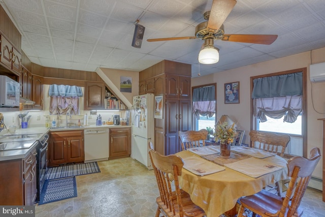 dining room featuring an AC wall unit, sink, and ceiling fan