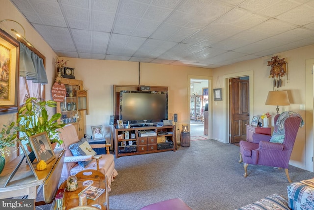 carpeted living room with a drop ceiling