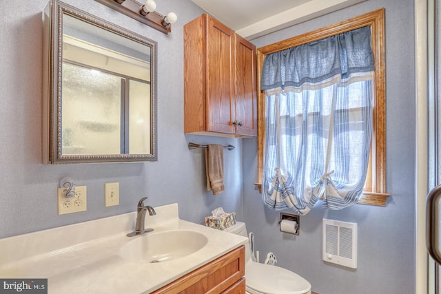 bathroom featuring vanity, toilet, and plenty of natural light