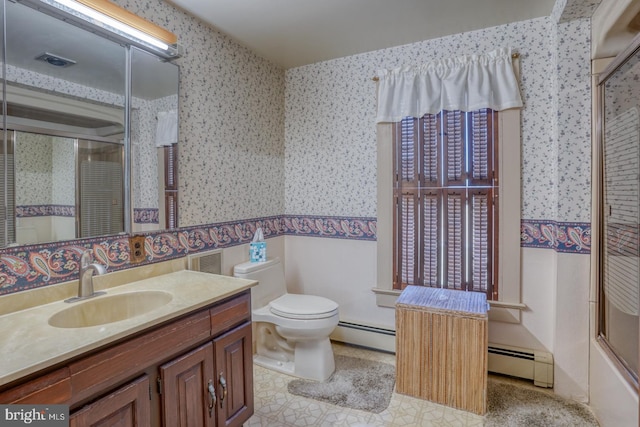 full bathroom with toilet, combined bath / shower with glass door, a baseboard heating unit, and vanity