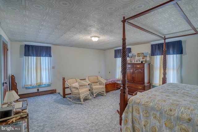 carpeted bedroom with a textured ceiling and a baseboard heating unit