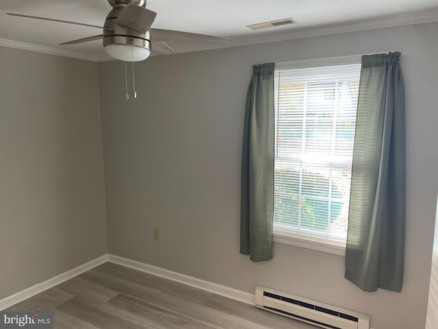 empty room with ceiling fan, hardwood / wood-style flooring, ornamental molding, and baseboard heating