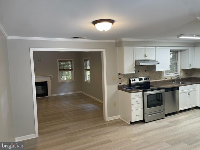 kitchen featuring appliances with stainless steel finishes, white cabinetry, and a healthy amount of sunlight