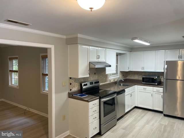 kitchen with stainless steel appliances, ornamental molding, sink, and white cabinets