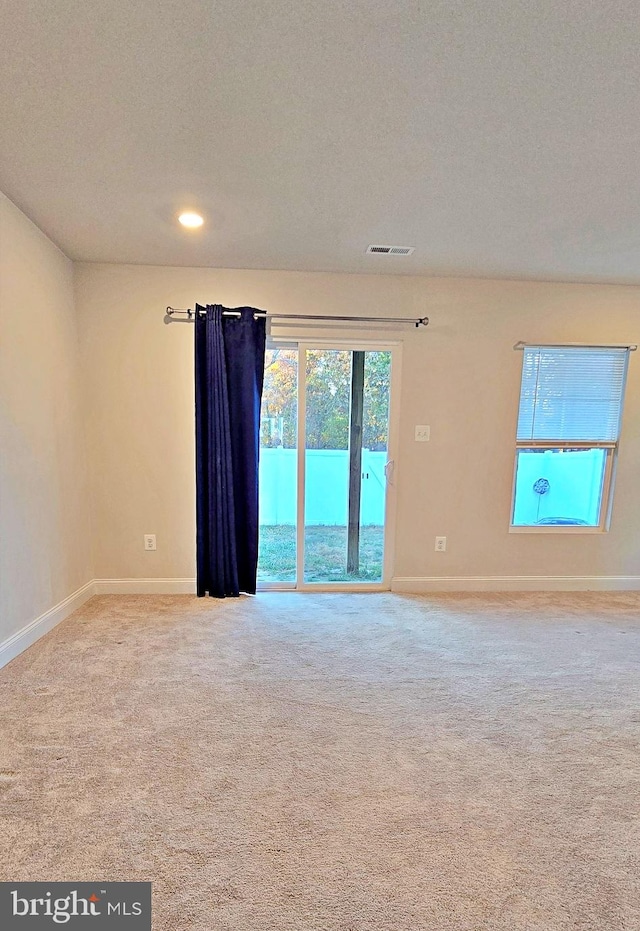 carpeted empty room featuring a textured ceiling