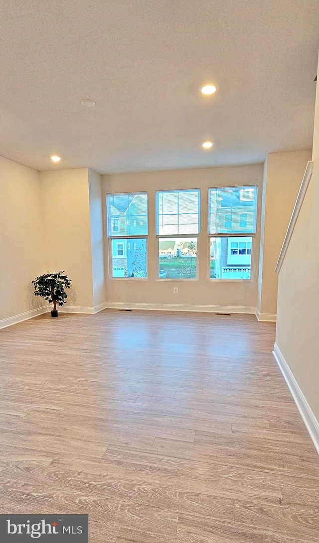 unfurnished living room with light wood-type flooring and a textured ceiling