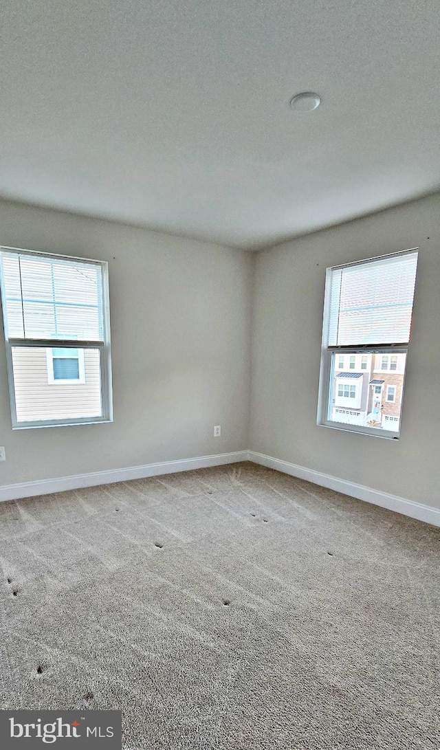 empty room with a textured ceiling and carpet floors