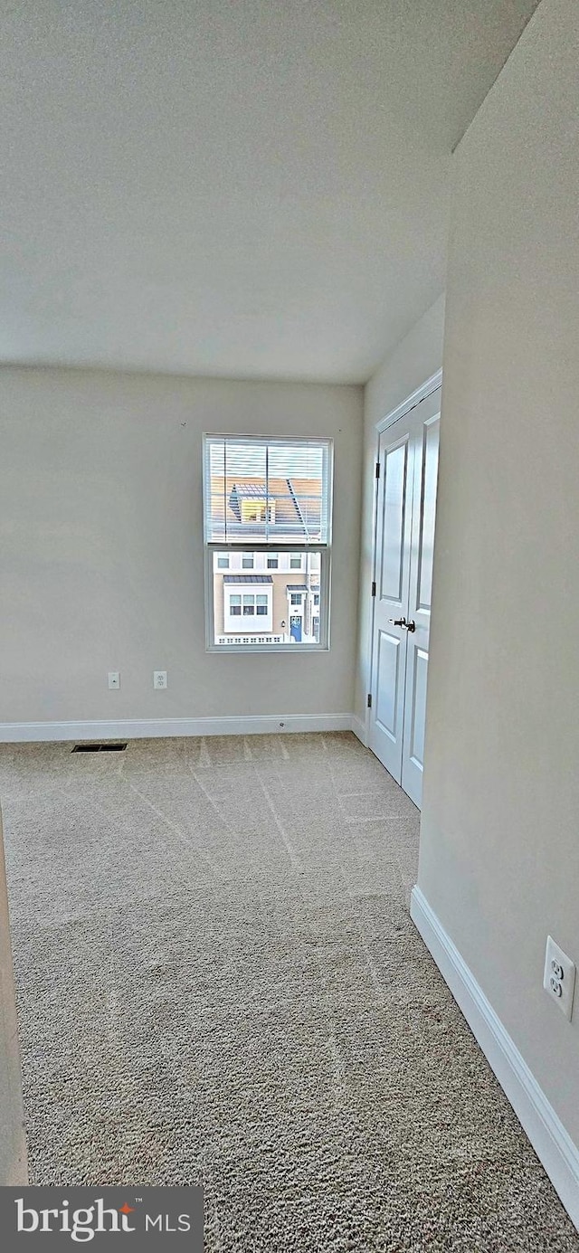 carpeted empty room with a textured ceiling