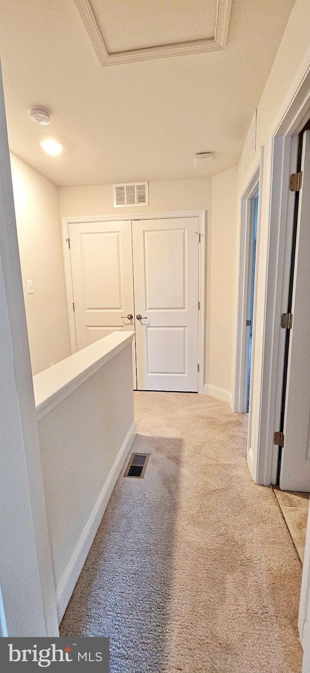 corridor featuring a textured ceiling and light carpet