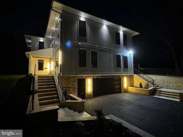 back house at night featuring a garage