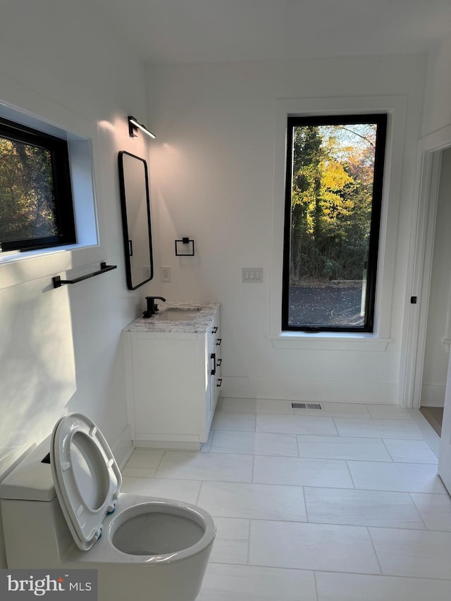 bathroom with tile patterned flooring, vanity, and toilet