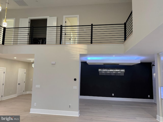 interior space with a towering ceiling and hardwood / wood-style flooring