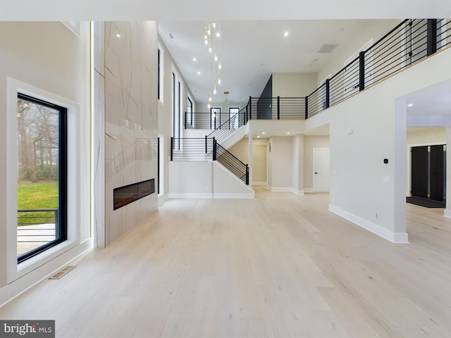 5005 Ravensworth Rd, Annandale, VA 22003 - foyer entrance featuring light wood-type flooring, stairs, baseboards, a high ceiling, and a tiled fireplace