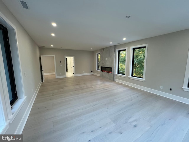 unfurnished living room featuring a fireplace and light hardwood / wood-style flooring