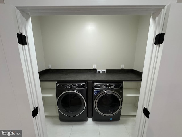 clothes washing area featuring light tile patterned floors and washer and dryer