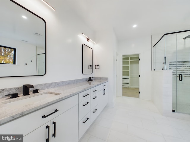 bathroom featuring a shower with door, vanity, and tile patterned flooring