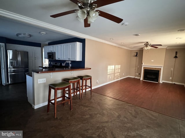 kitchen featuring white cabinetry, dark hardwood / wood-style floors, kitchen peninsula, a kitchen bar, and appliances with stainless steel finishes