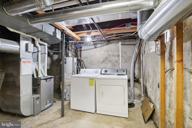 laundry area with washer and dryer, heating unit, and water heater