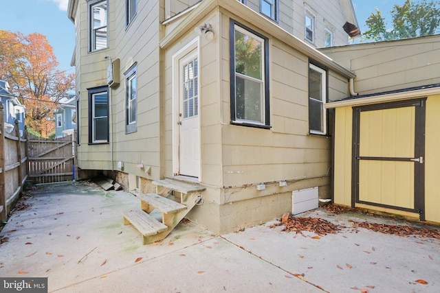 view of side of home with a patio area and a storage unit