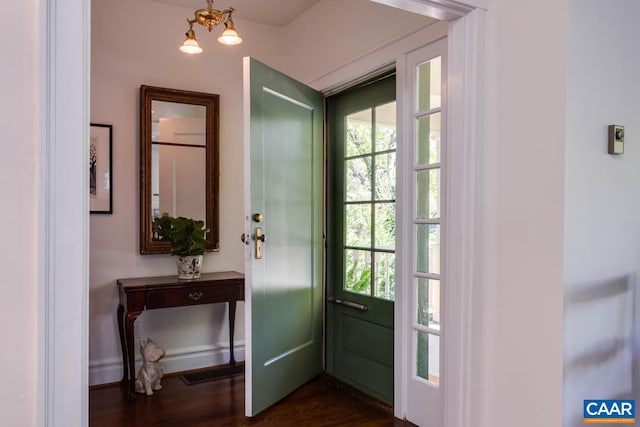 entryway with an inviting chandelier and dark hardwood / wood-style flooring