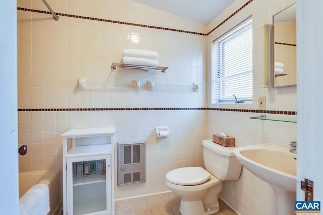 full bathroom with sink, toilet, tile walls, heating unit, and tile patterned flooring