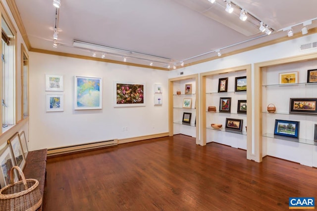 interior space featuring crown molding, track lighting, baseboard heating, and dark hardwood / wood-style floors