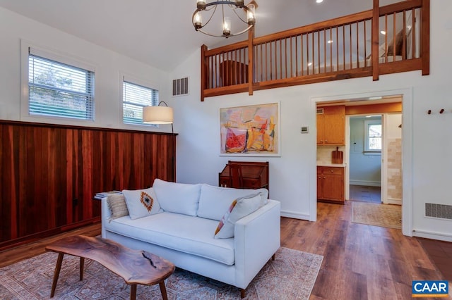 living room with high vaulted ceiling, a chandelier, and dark hardwood / wood-style floors