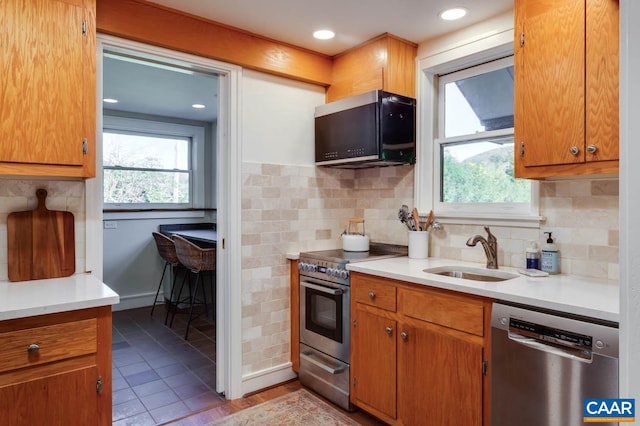 kitchen with light tile patterned floors, appliances with stainless steel finishes, sink, and decorative backsplash