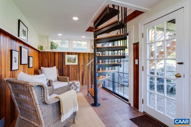 living area with wood walls, tile patterned floors, and plenty of natural light