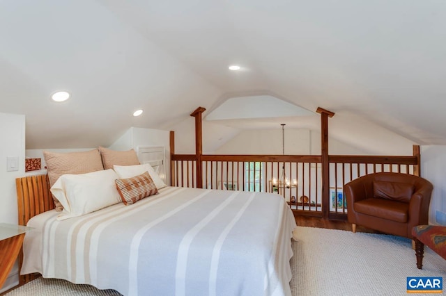 carpeted bedroom featuring lofted ceiling and a chandelier