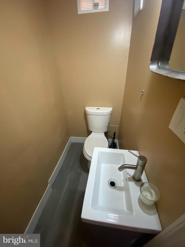 bathroom with toilet, hardwood / wood-style floors, and sink