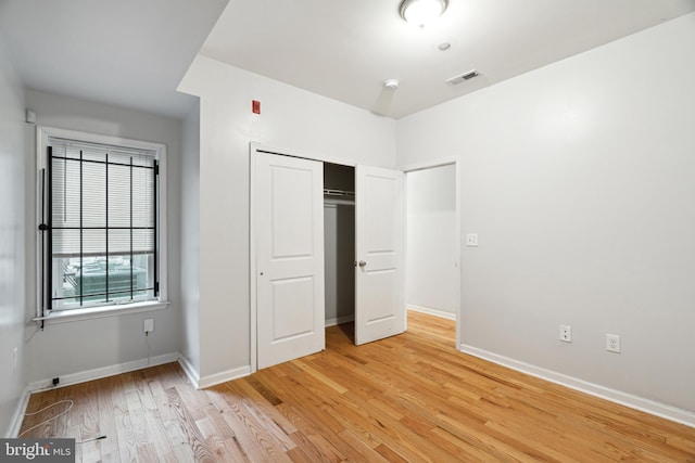 unfurnished bedroom featuring a closet and light hardwood / wood-style floors