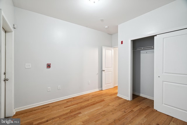 unfurnished bedroom featuring a closet and light wood-type flooring