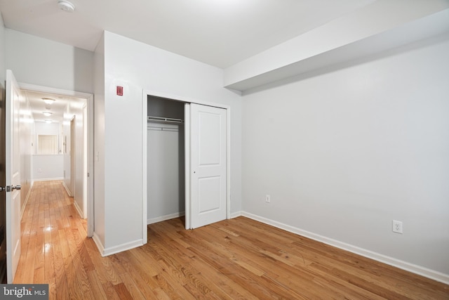 unfurnished bedroom featuring a closet and light wood-type flooring