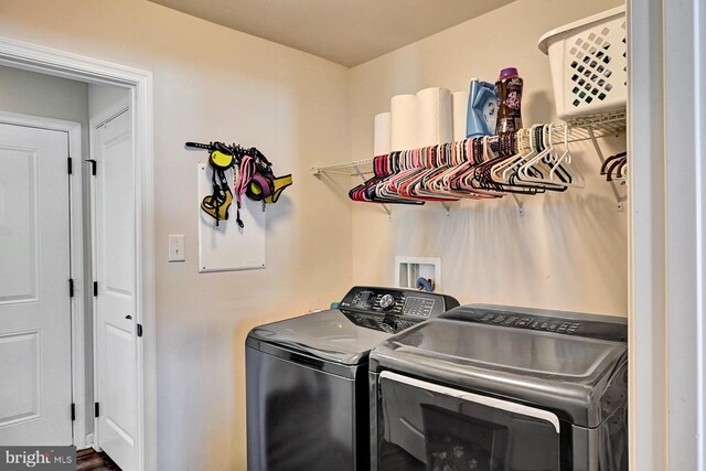 clothes washing area featuring washer and clothes dryer and wood-type flooring