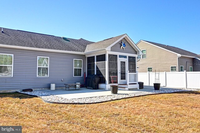 back of house featuring a patio, a sunroom, and a yard