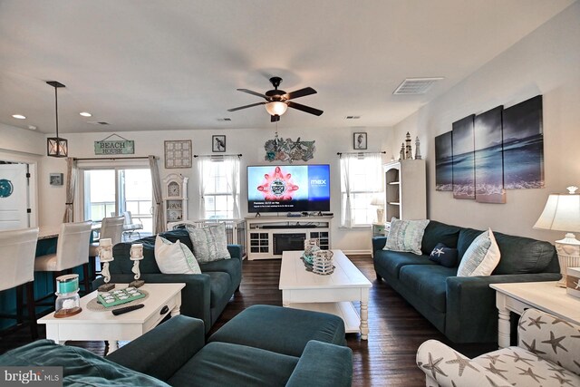 living room with dark wood-type flooring and ceiling fan