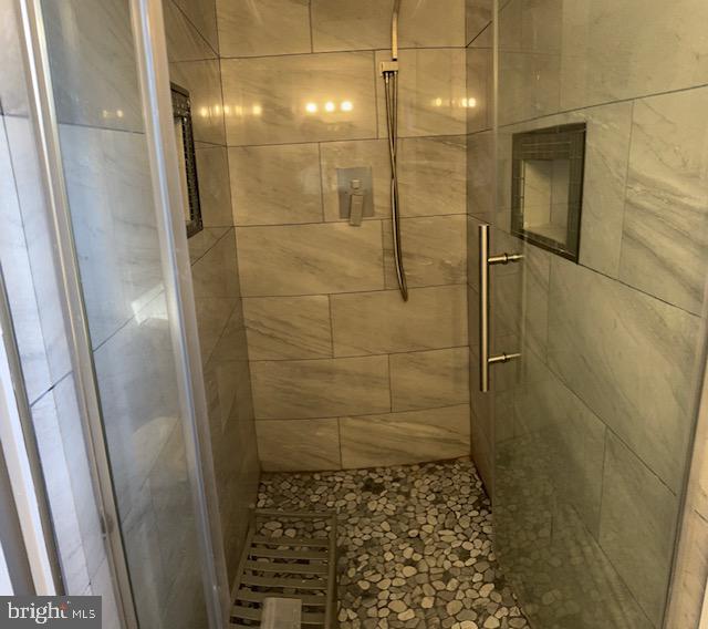 bathroom featuring a shower with door