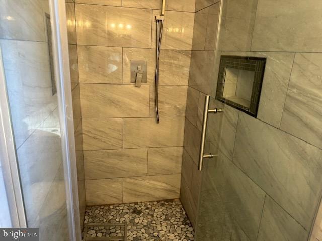 bathroom with a shower with door