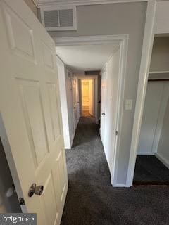 hall featuring dark colored carpet