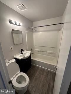 full bathroom featuring hardwood / wood-style floors, vanity, toilet, and shower / washtub combination