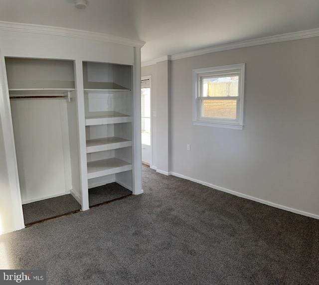 unfurnished bedroom featuring dark colored carpet and ornamental molding