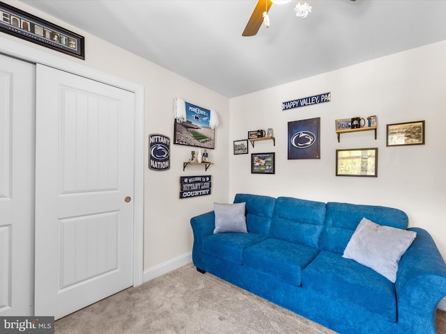 carpeted living room with ceiling fan