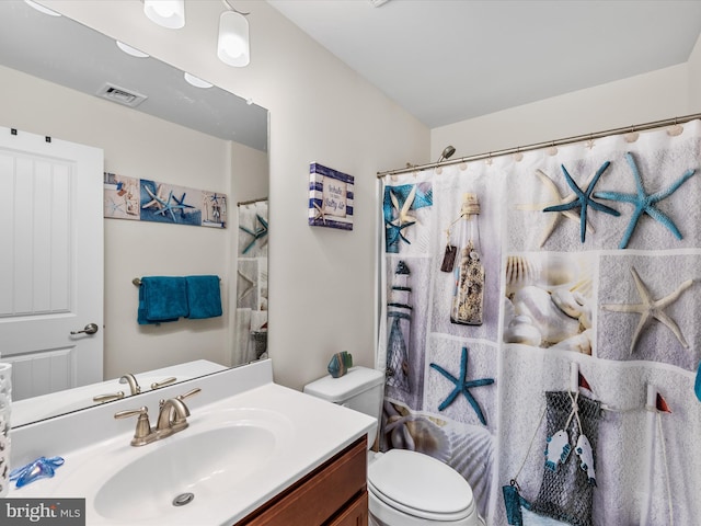 bathroom with vanity, a shower with shower curtain, and toilet